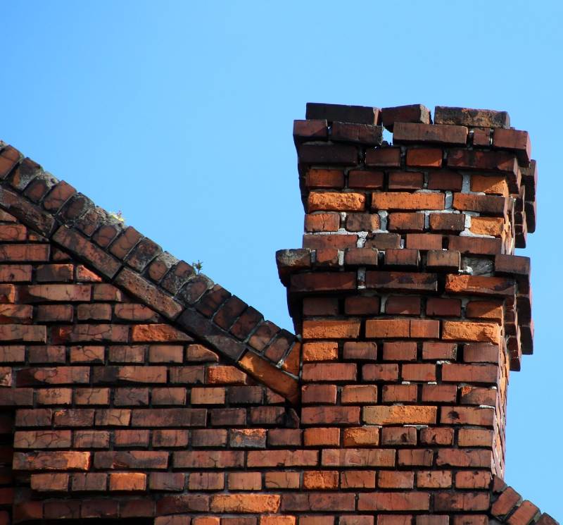 Signs Your Chelsea Home Needs a Chimney Inspection Blog Article - Damaged chimney on an Chelsea home showing cracks and missing mortar